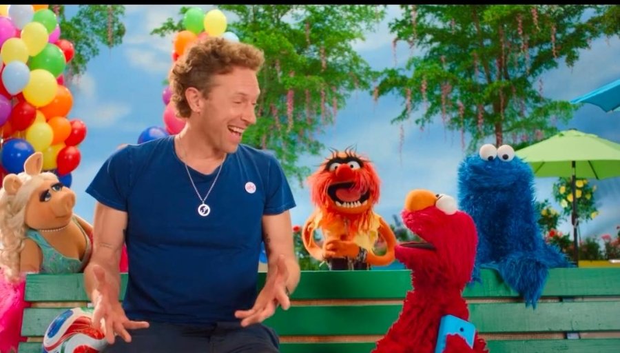 Chris Martin and Elmo in the announcement video. Elmo suggested Madonna. Animal wanted Shakira. Cookie Monster said BTS